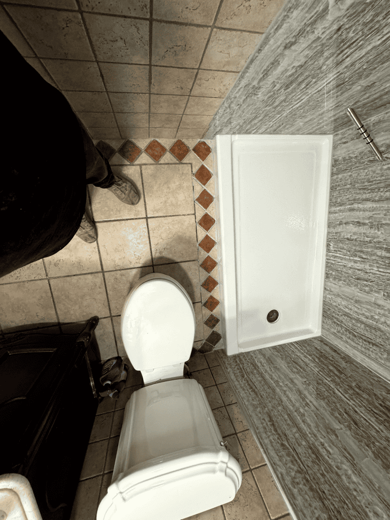 Shower and toilet in a contemporary bathroom with stylish tile design and modern fixtures.