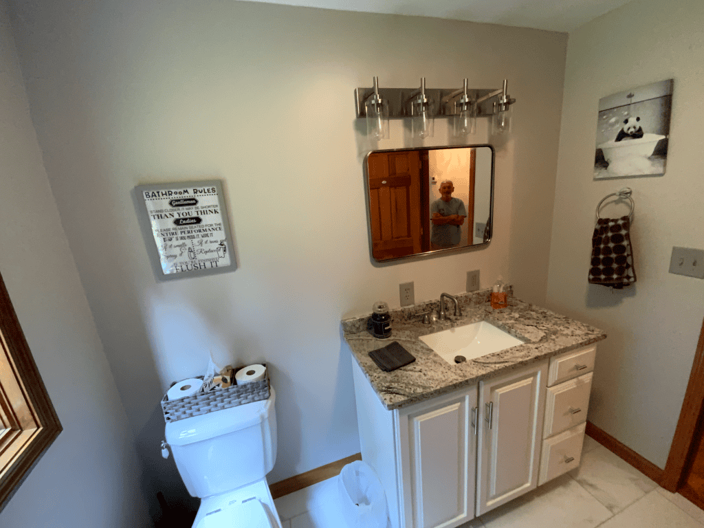 Modern bathroom vanity with granite countertop and wall mirror in a clean, bright space.