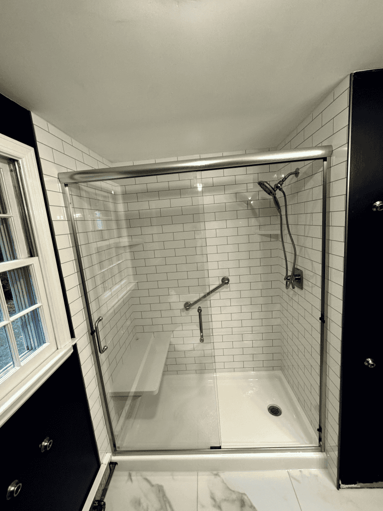 Spacious walk-in shower with glass enclosure, white subway tiles, and modern fixtures. Perfect for a.