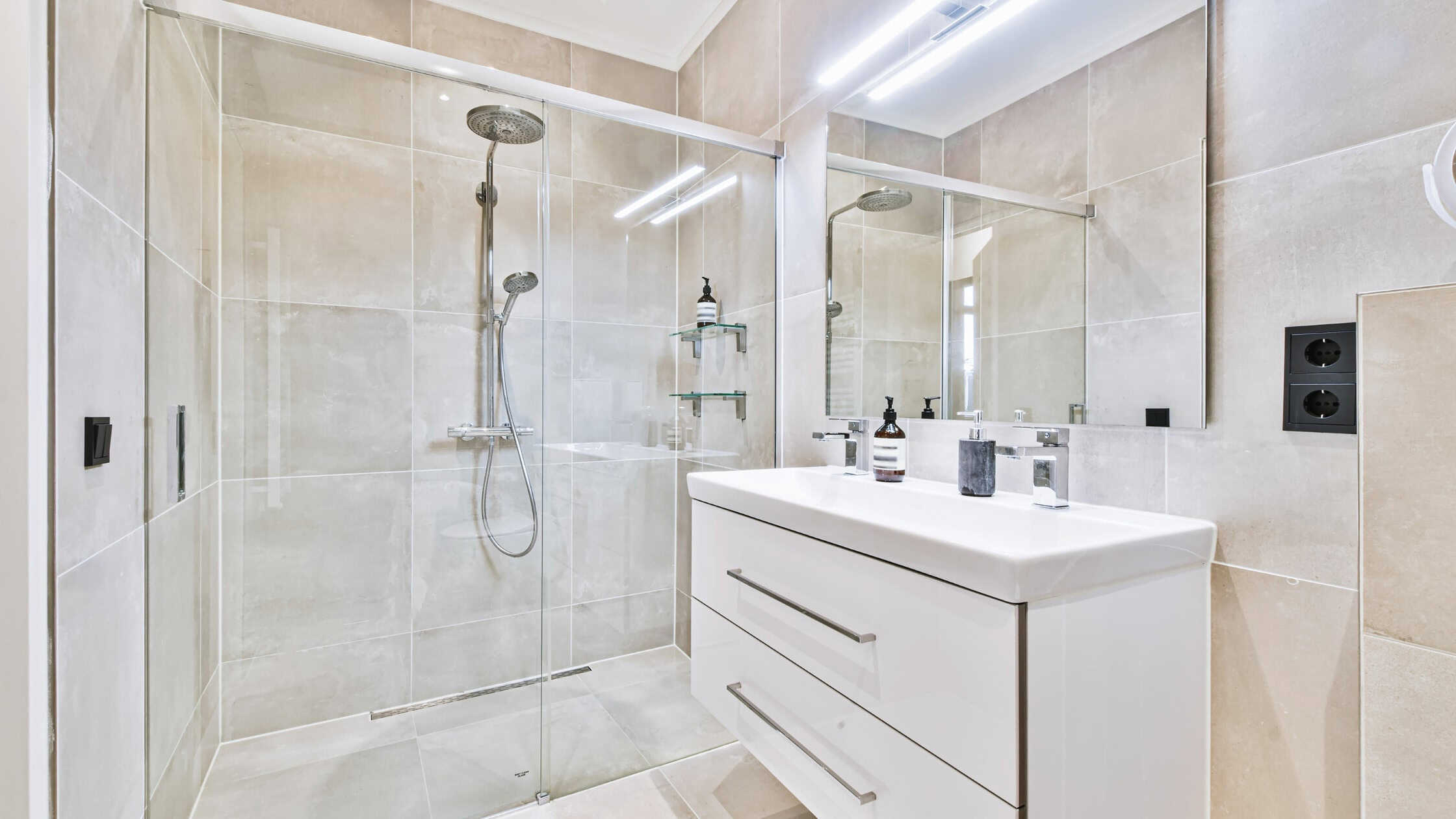 Modern bathroom with walk-in shower, glass enclosure, and sleek vanity.