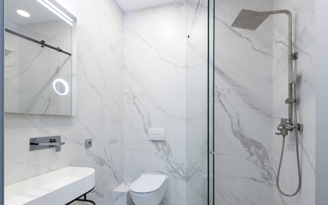 Modern bathroom with sleek shower and marble walls, showcasing contemporary design and luxurious fix.
