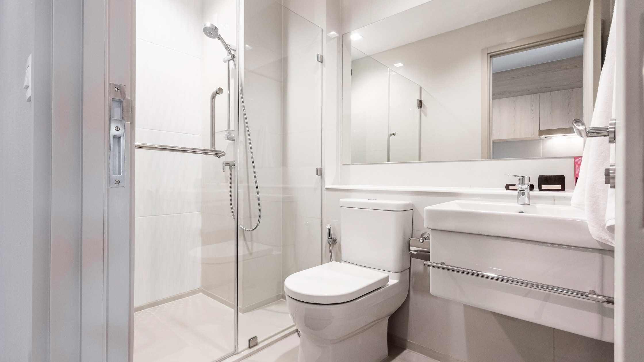 Modern bathroom with walk-in shower, toilet, and sleek vanity in a bright, clean space.
