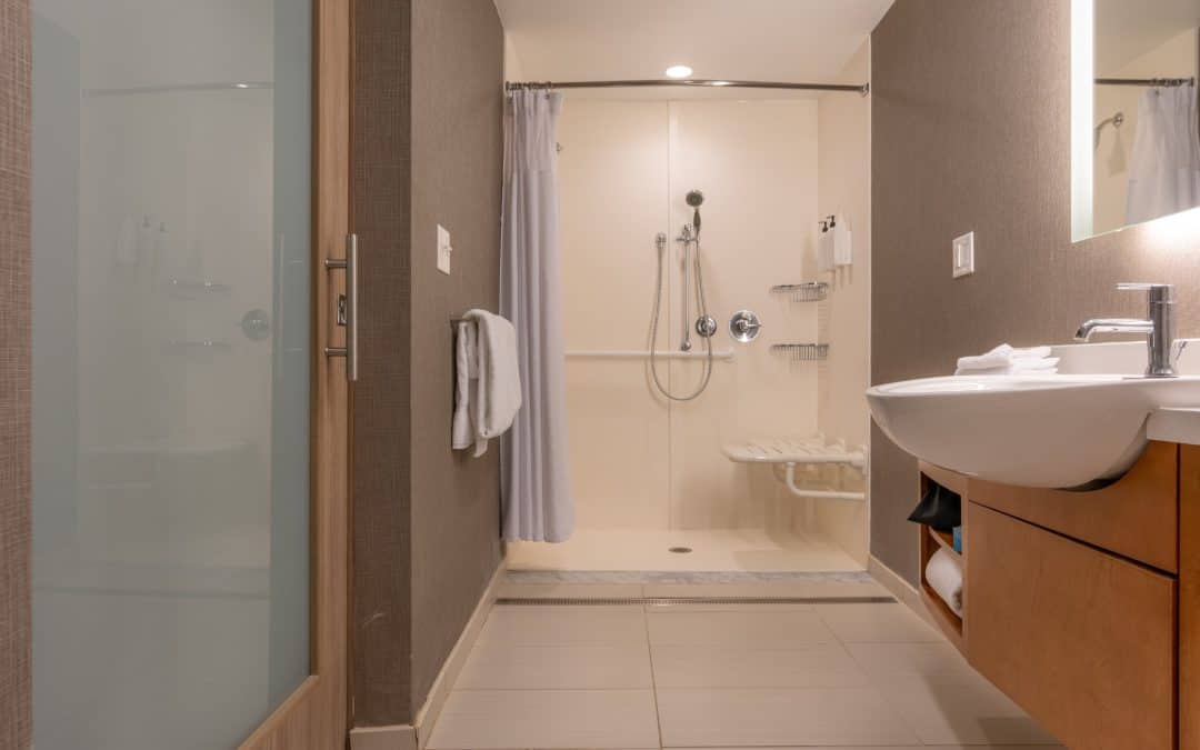 Modern bathroom with walk-in shower, sink, and contemporary design elements.