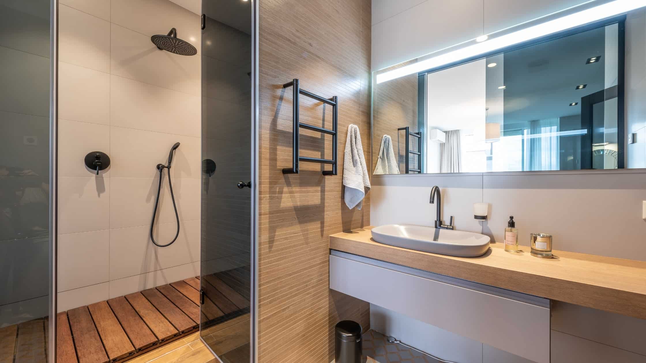 Contemporary bathroom with dual shower heads and wooden accents for a luxurious spa-like experience.