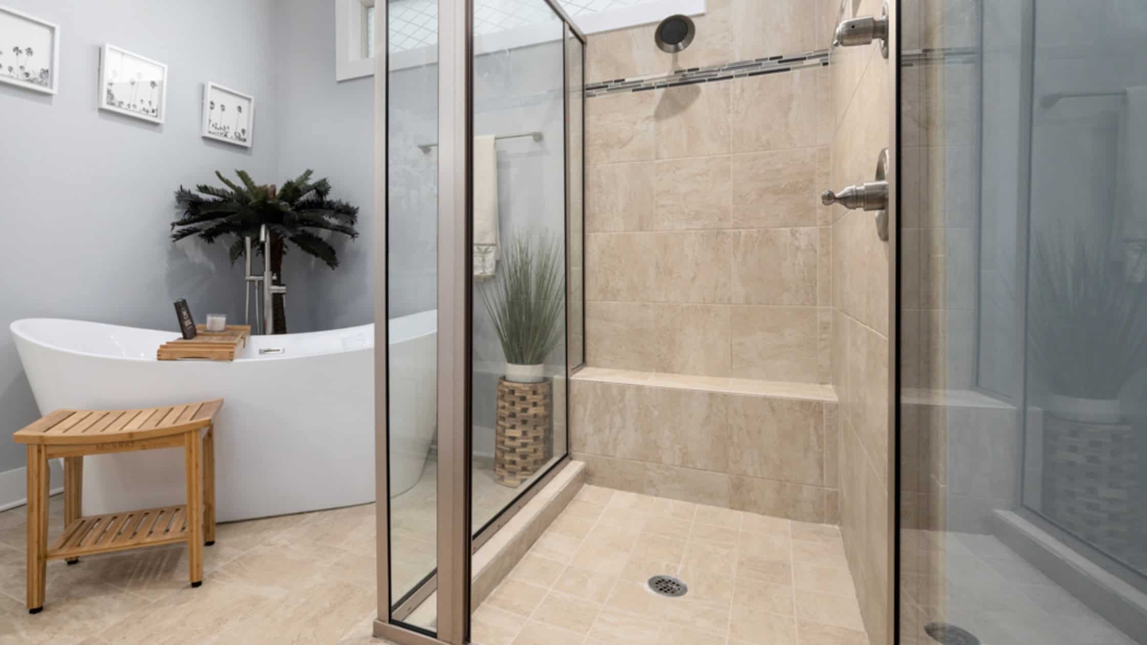 Spacious walk-in shower with glass enclosure and beige tiles in a modern bathroom.