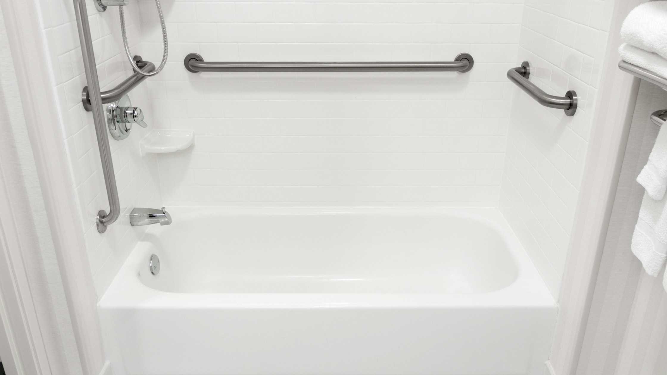 Accessible walk-in bathtub with safety grab bars for elderly and disabled users.