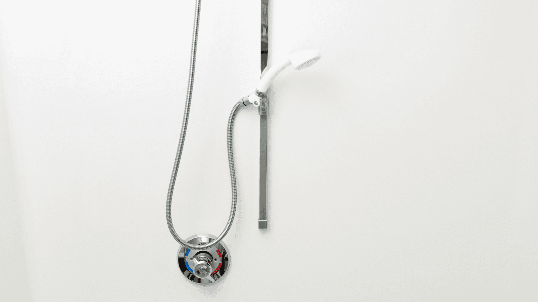 Close-up of a sleek, modern shower system with handheld showerhead and wall controls.