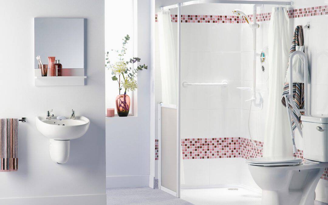 Bright bathroom with walk-in shower, toilet, and sink, featuring clean design and natural light.