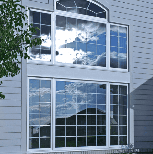 Large reflective house window with multiple panes.