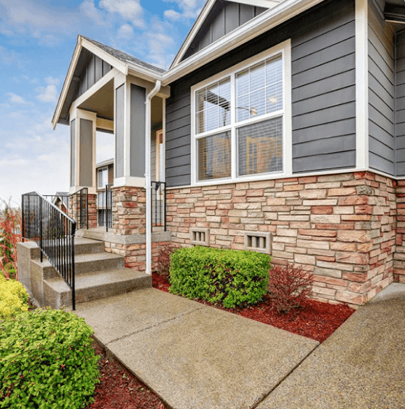 Beautiful modern house with stone accents and large windows in a suburban neighborhood.