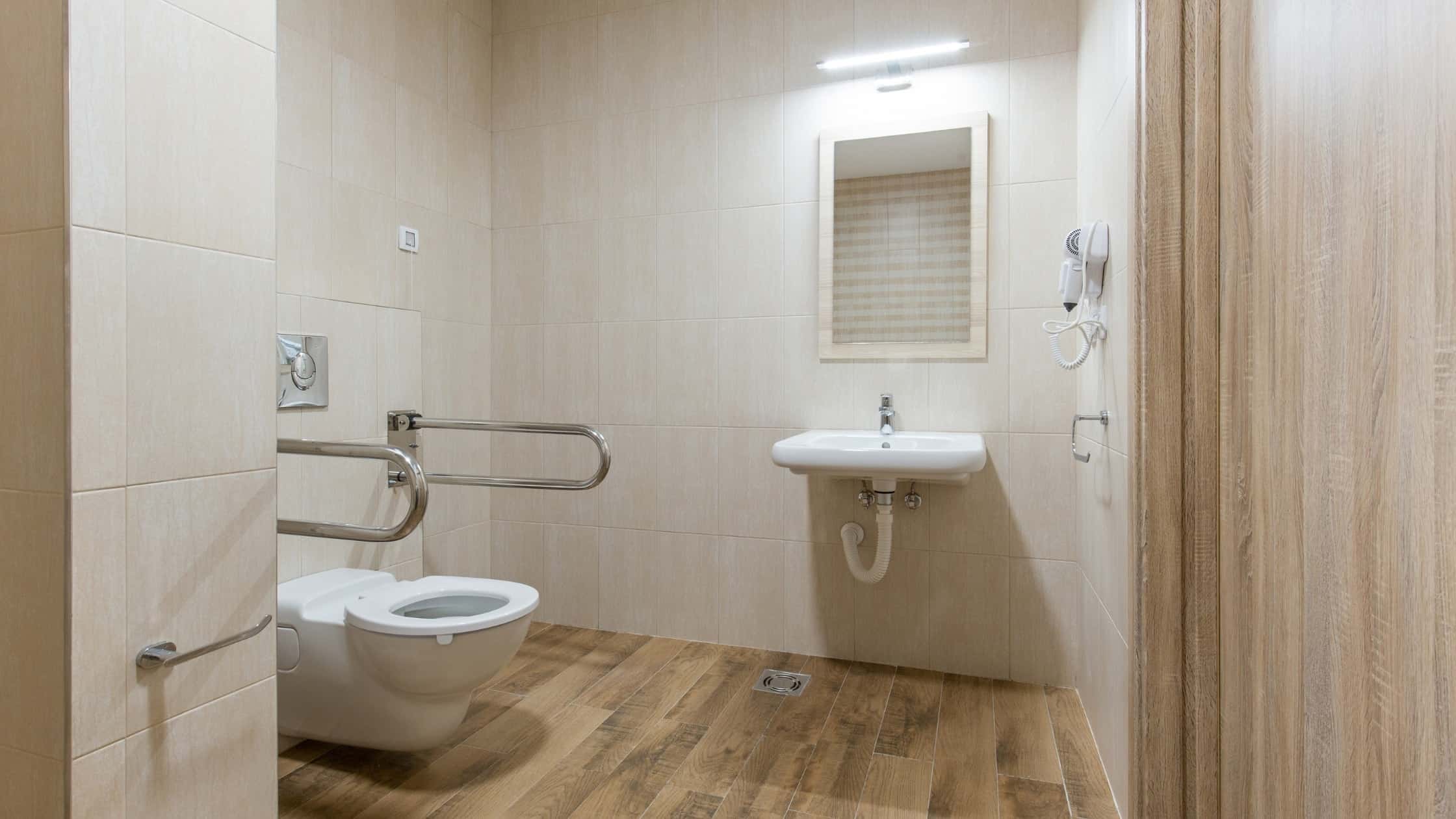 Accessible bathroom with toilet and sink for comfort and safety.