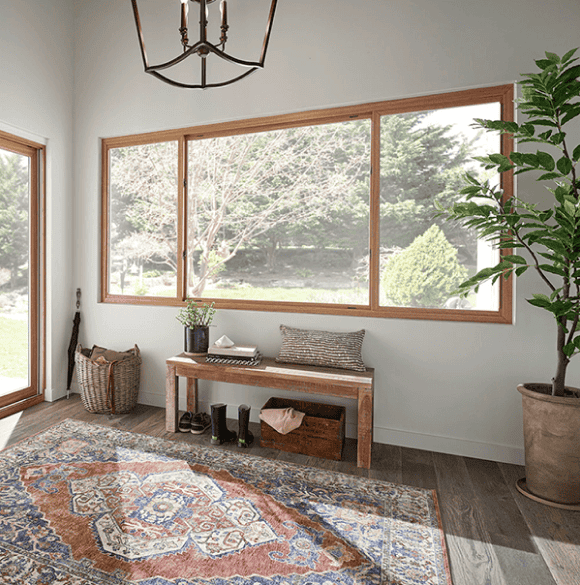 Bright sunlit room with large windows and wooden accents.