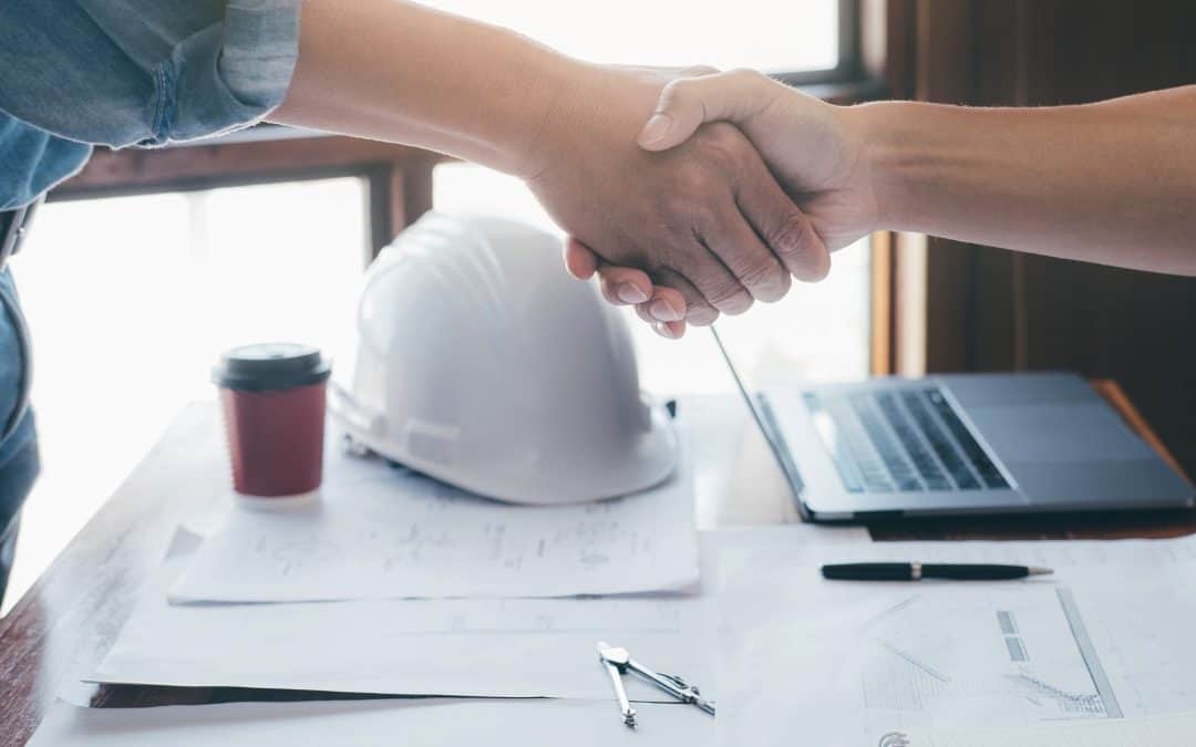Handshake between two professionals in a modern office setting.
