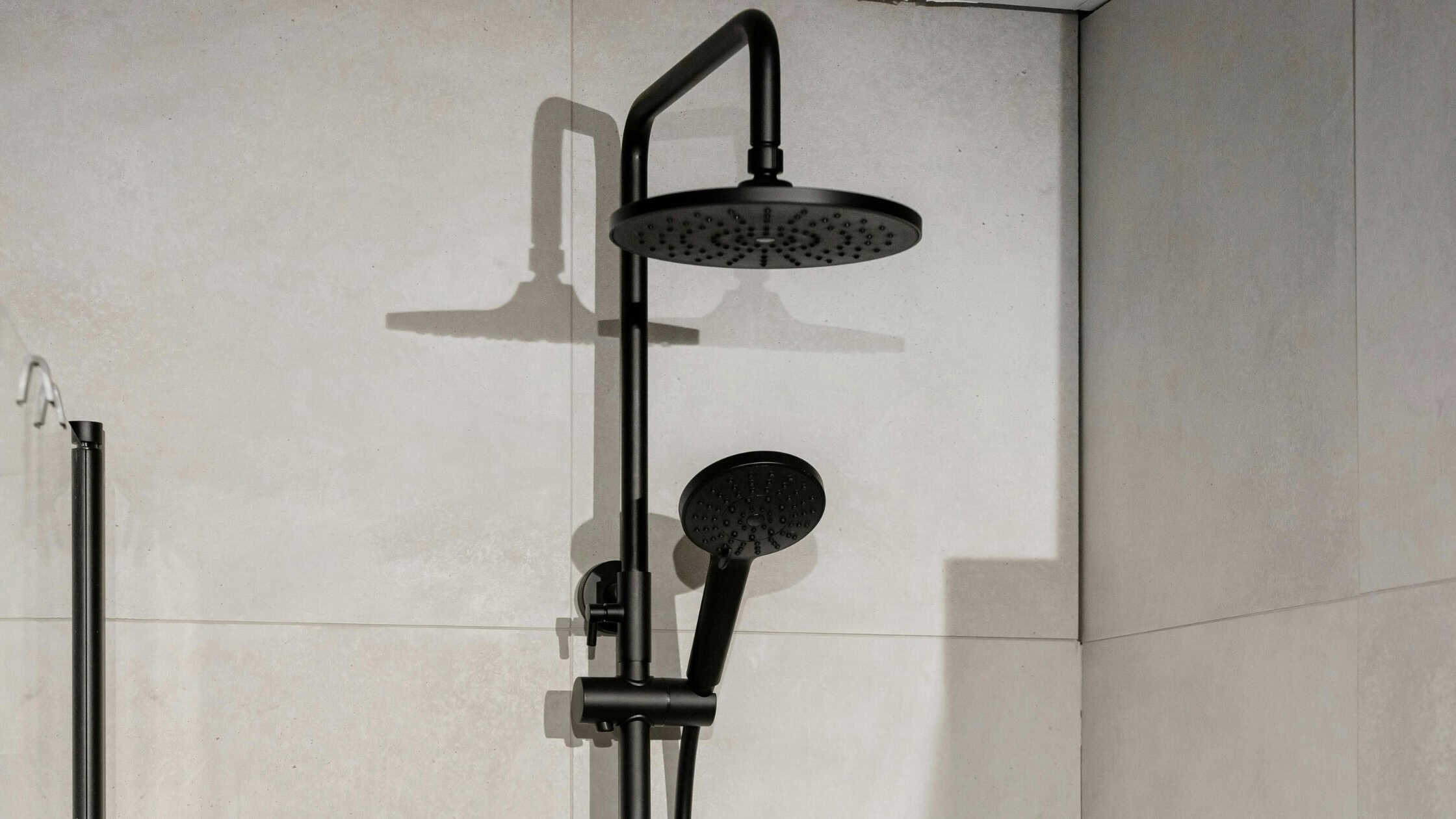Stylish black shower system with rain shower and handheld spray for a luxurious bathroom upgrade.