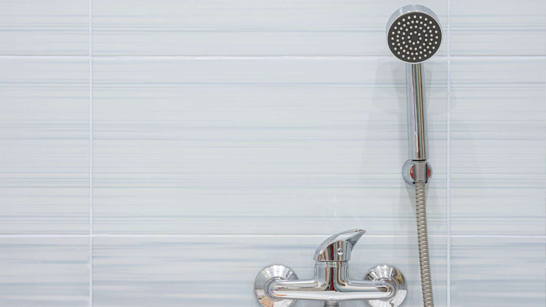 Modern shower faucet with handheld showerhead in a sleek bathroom setting.