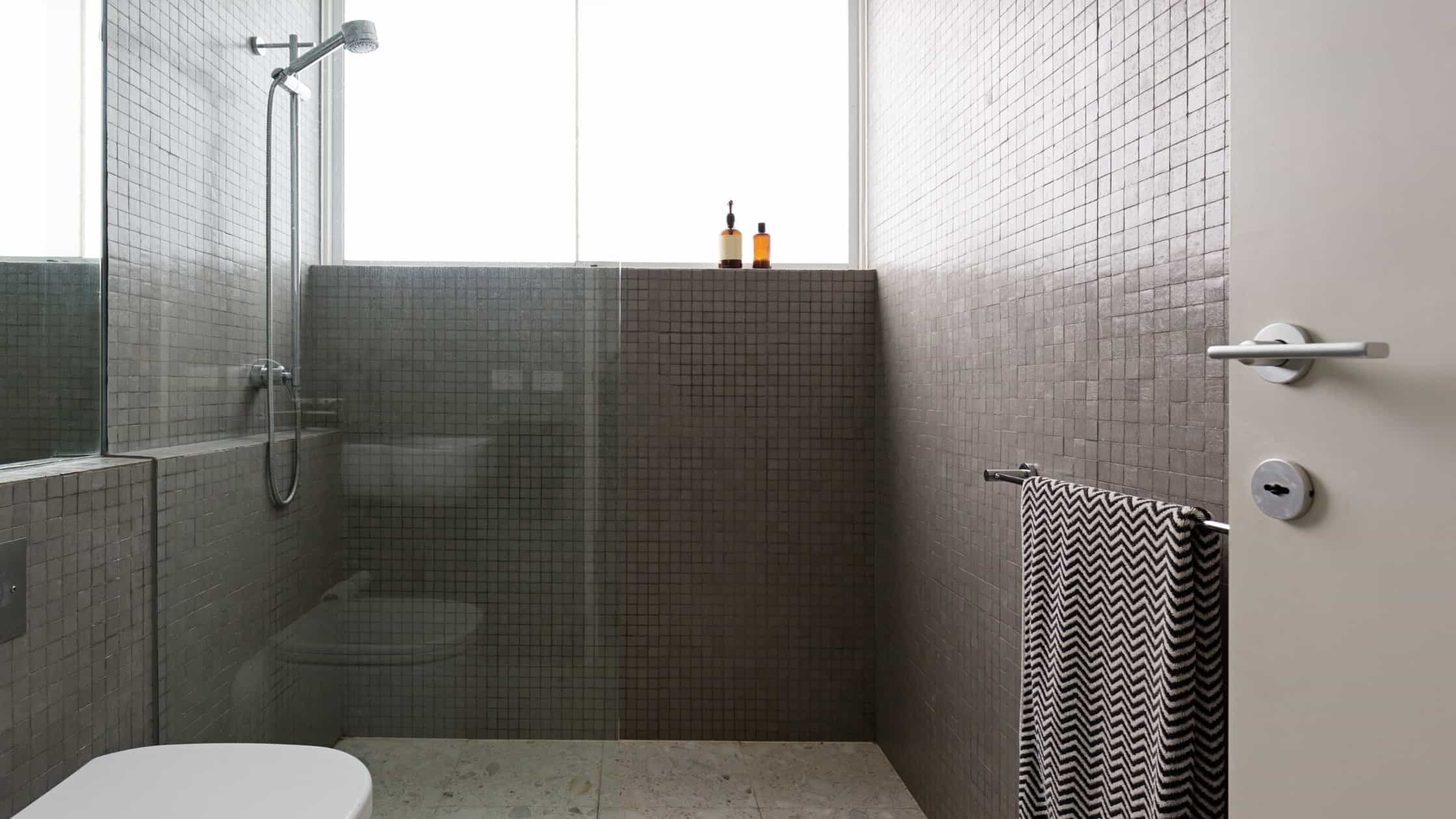 Modern bathroom shower with glass partition and tiled walls for a sleek look.