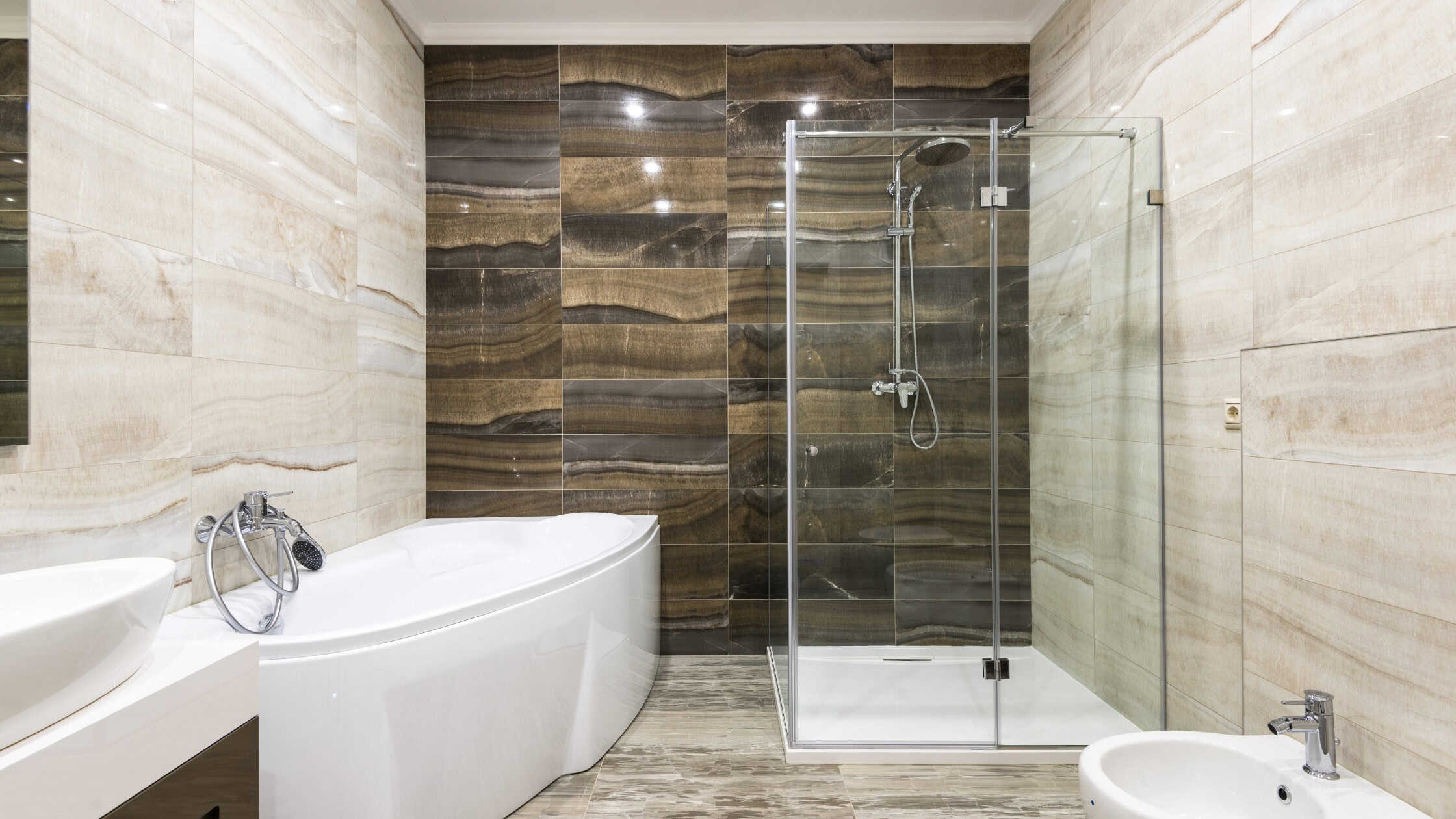 Elegant bathroom featuring a glass-enclosed shower and a freestanding bathtub with stylish wall tile.