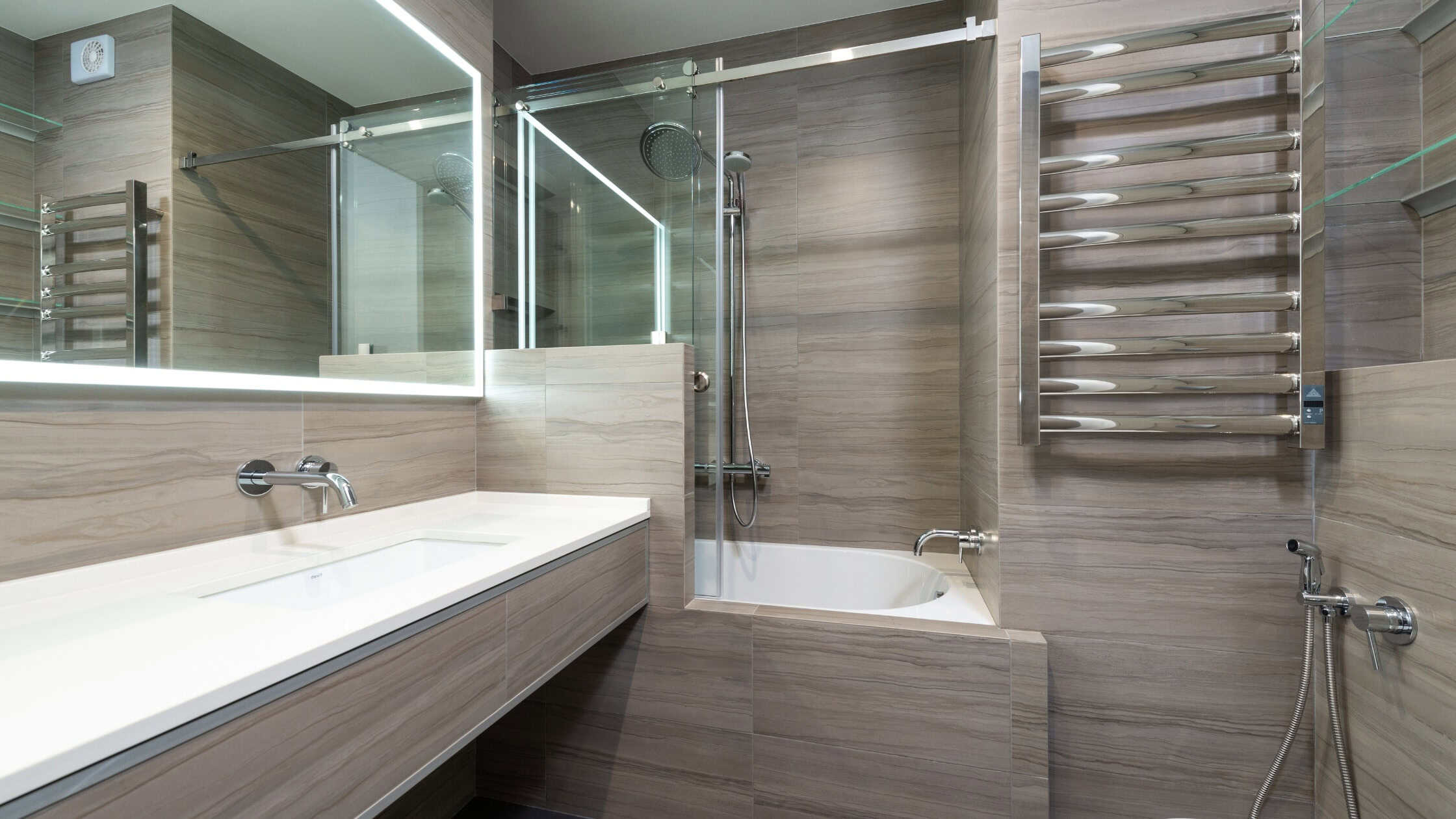 Bright and sleek bathroom with a glass shower enclosure, wall-mounted towel warmer, and contemporary.