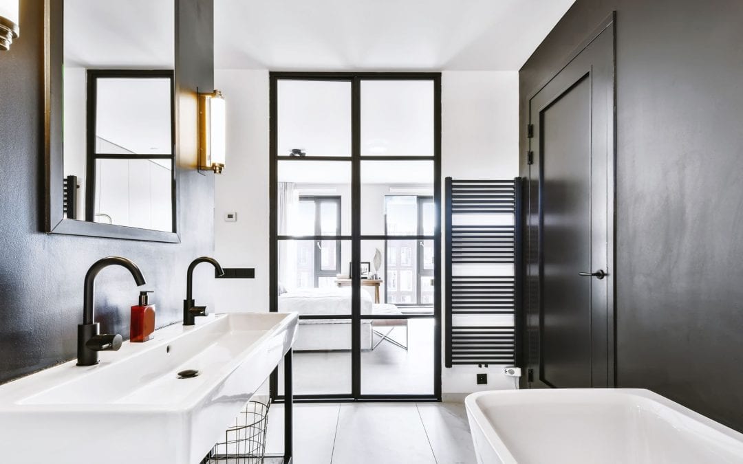 Elegant black and white bathroom with dual sinks and a spacious bathtub. Perfect for contemporary ho.