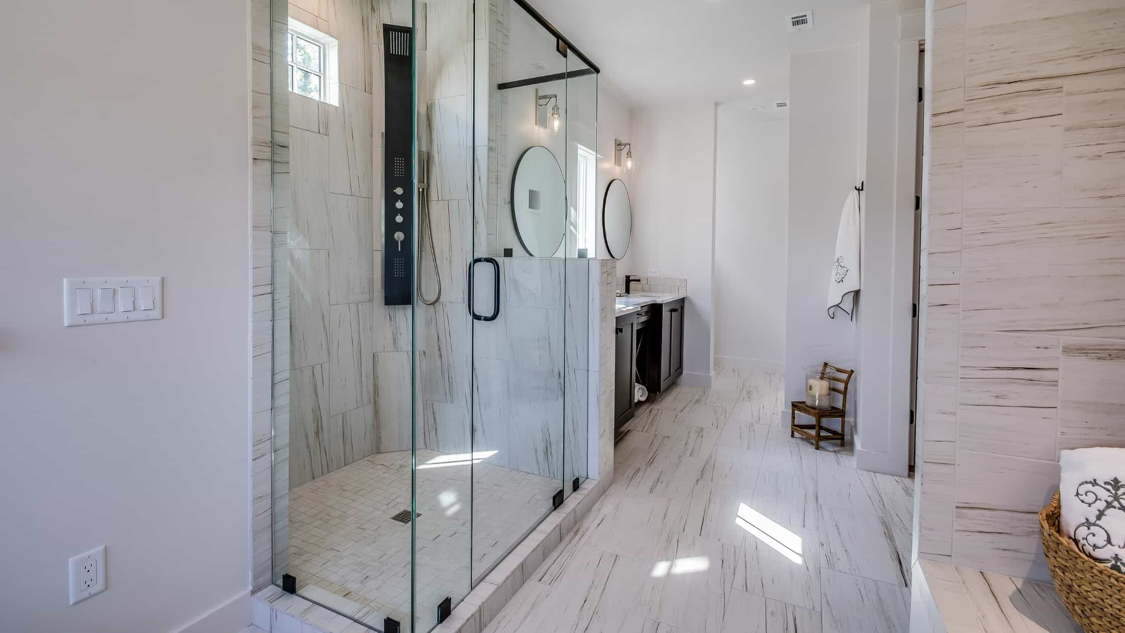 Glass-enclosed walk-in shower with sleek fixtures in a contemporary bathroom.