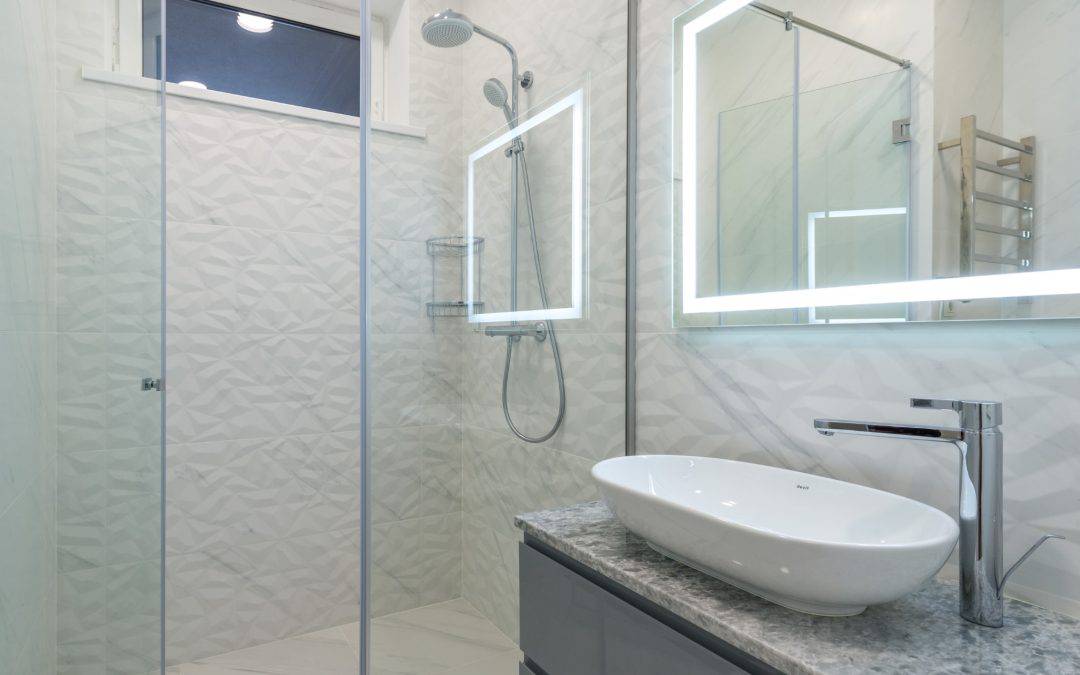 Contemporary bathroom with sleek vessel sink and illuminated mirror for a stylish, functional space.