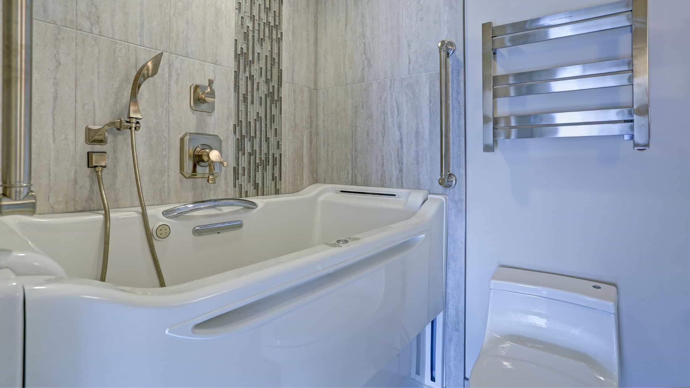 Modern bathroom featuring a sleek bathtub, wall-mounted towel warmer, and contemporary fixtures.