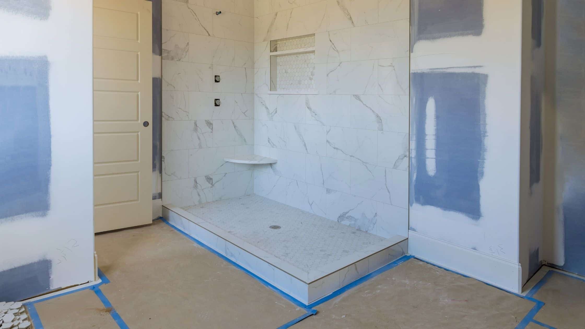 Walk-in shower featuring elegant marble tiles and a built-in bench, perfect for a luxurious bathroom.