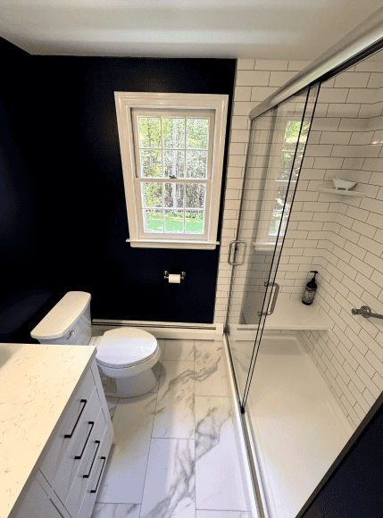 Modern Bathroom Shower Modern bathroom with glass-enclosed shower and white subway tiles. Bright space with a window overlo.
