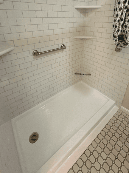 Modern Shower Area Accessible shower with grab bar and white subway tiles.