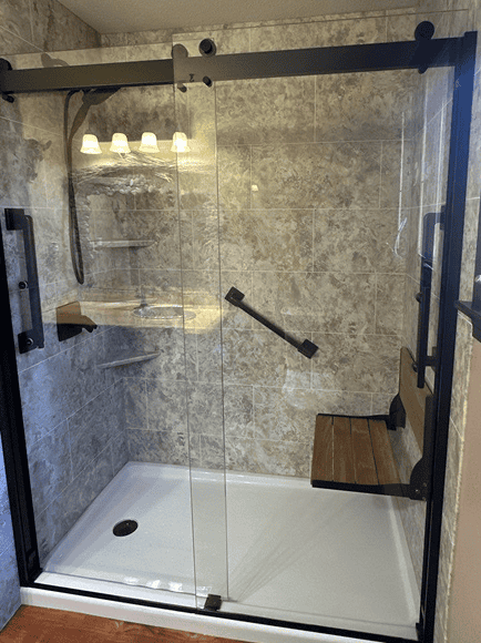 Accessible walk-in shower with glass enclosure and built-in bench.