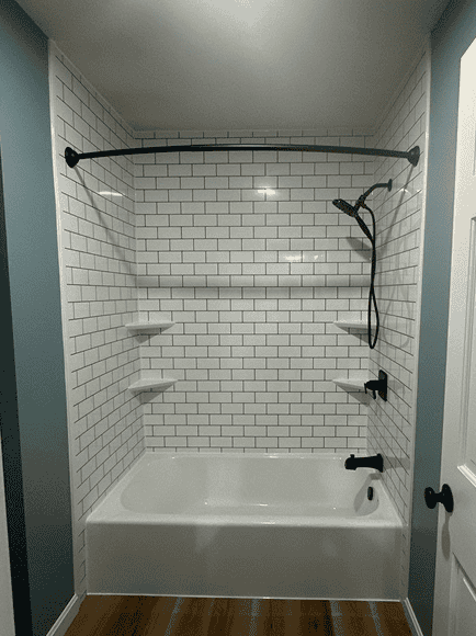 Modern shower with white subway tiles, black fixtures, and a built-in bathtub.