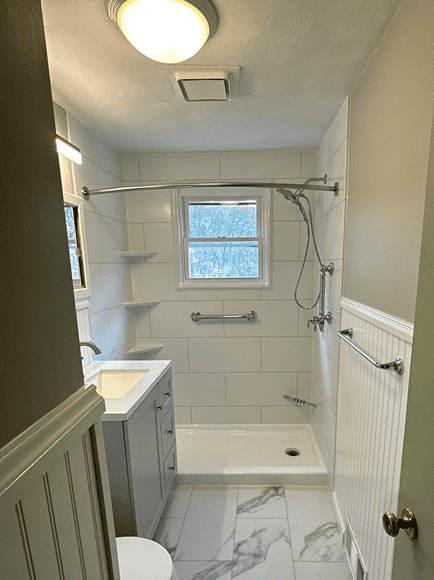 Bathroom Renovation Shower Area Bathroom shower with white tiles and a small window for natural light.