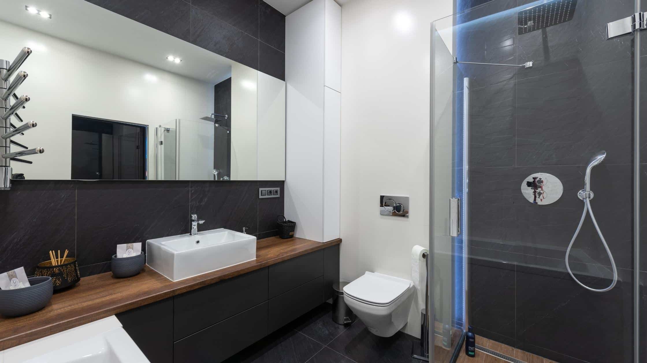 Modern bathroom with sleek vanity, large mirror, and walk-in shower for a stylish, functional space.