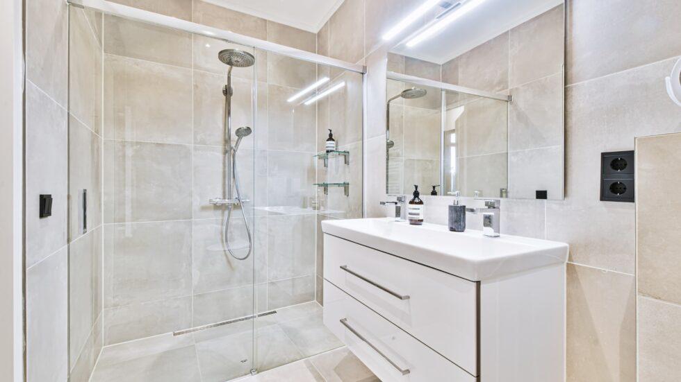 Modern bathroom with walk-in shower, glass enclosure, and sleek vanity.